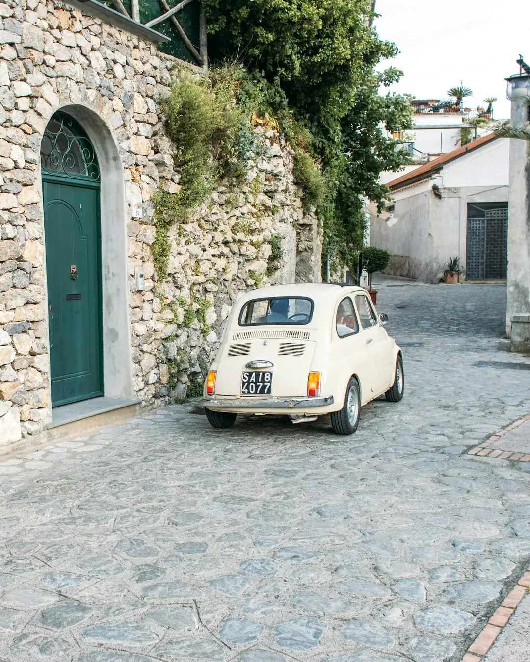 Una piccola auto d'epoca in una via di paese in pietra
