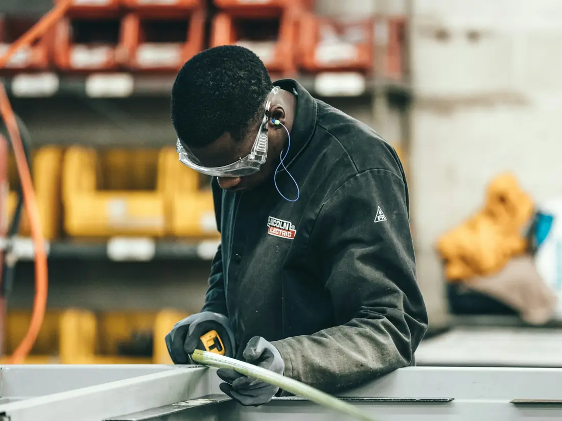 Un operaio misura un telaio in officina