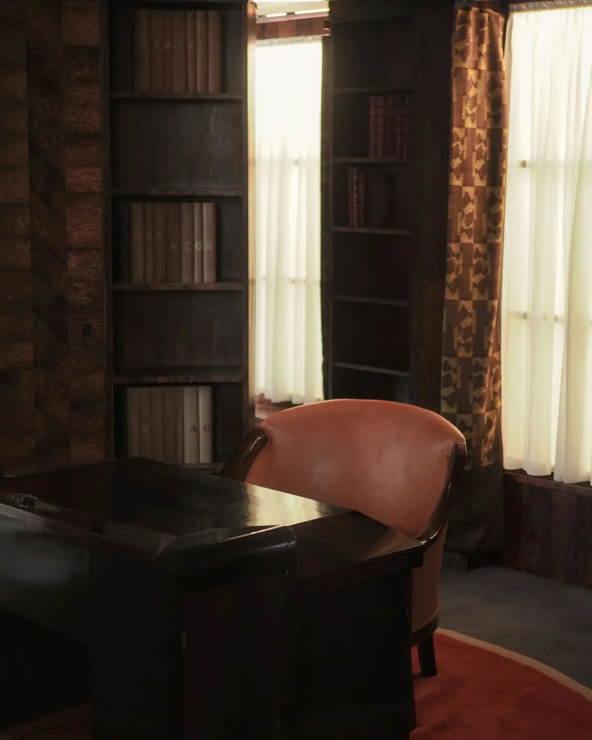 Una stanza dello studio, con la libreria e la poltrona in pelle
