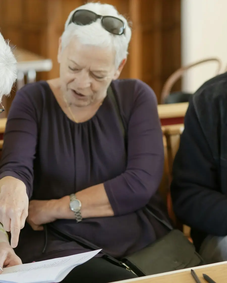 Tre pensionati leggono insieme un documento
