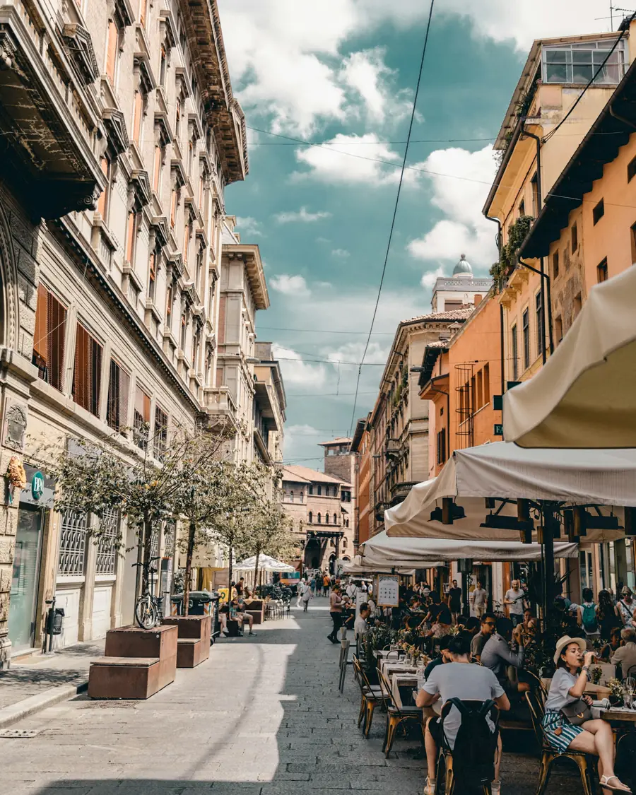 Una via di Bologna con i portici e i tavolini