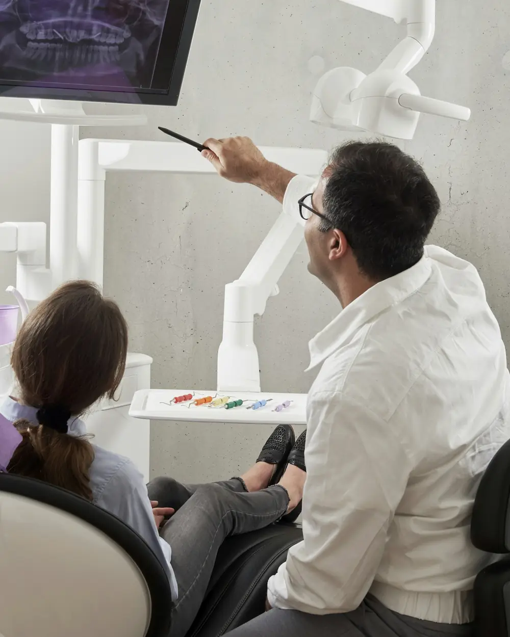 Il dentista mostra lo schermo a una bambina sulla poltrona