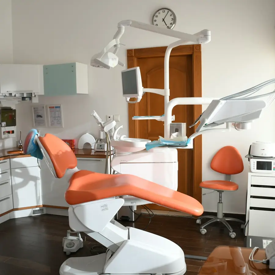 Poltrona del dentista arancione vicino alla finestra