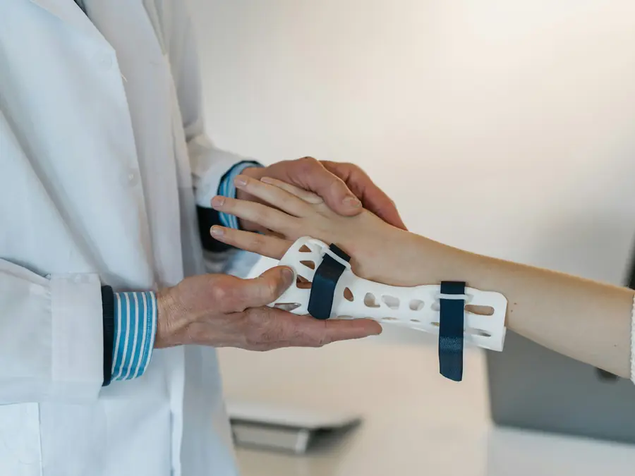 Il medico sistema un tutore al polso