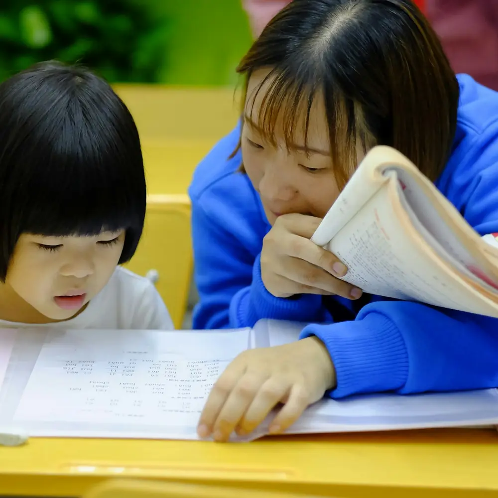 Educatrice che aiuta una bambina a fare i compiti