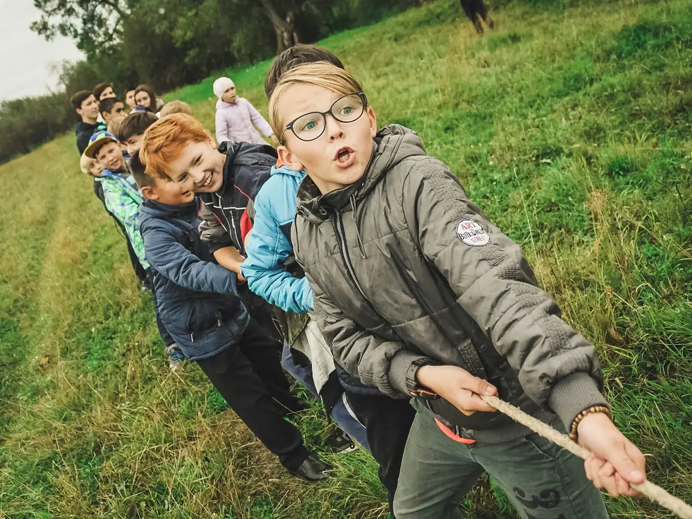 Bambini che giocano al tiro alla fune sul prato