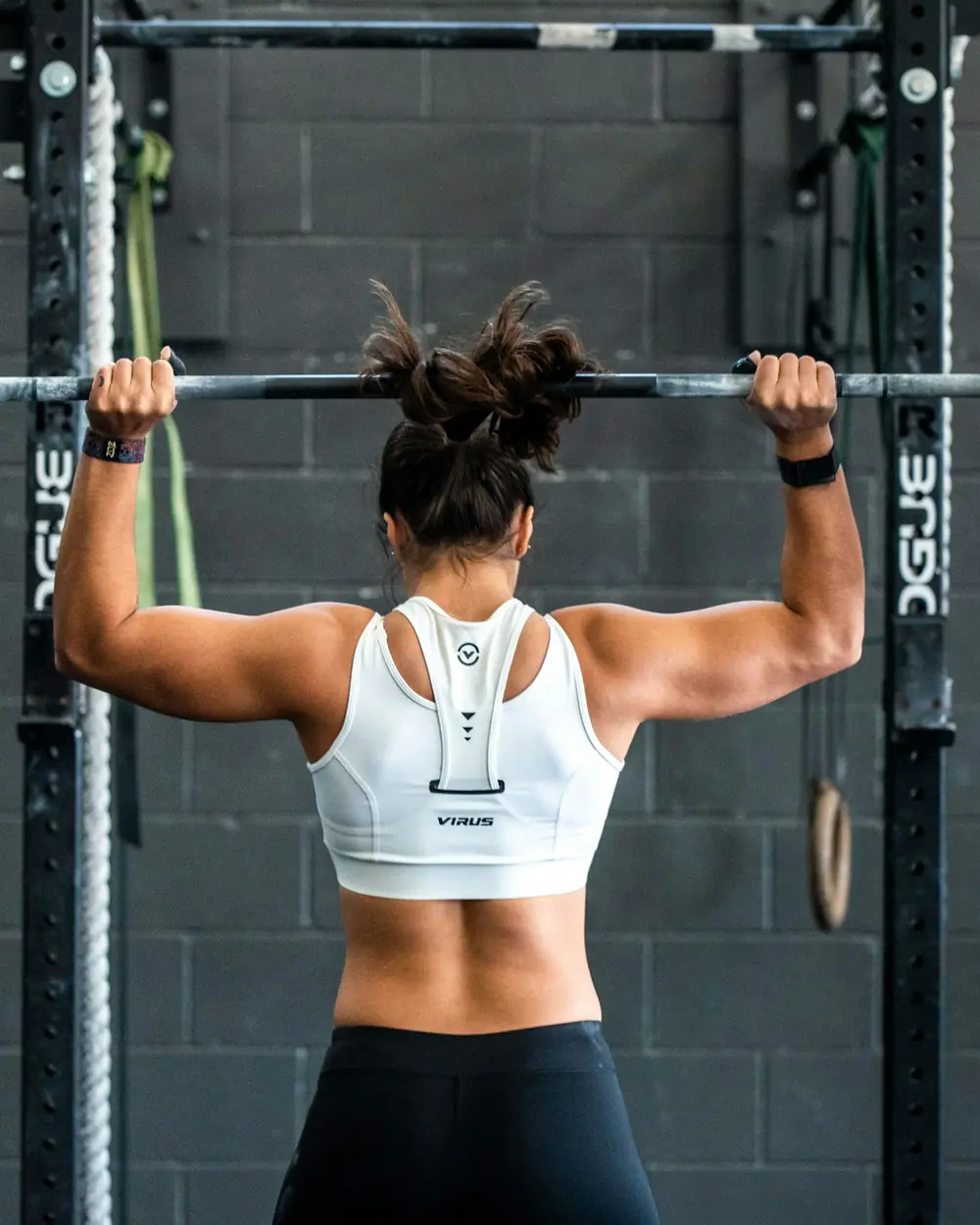 Atleta con il bilanciere sulle spalle davanti al rack