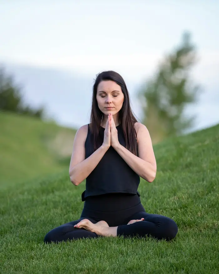 Elena, insegnante di meditazione, seduta sul prato