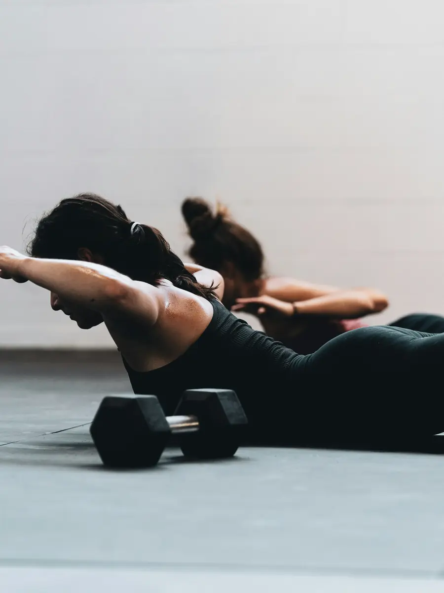 Esercizio di pilates sul tappetino con piccoli pesi