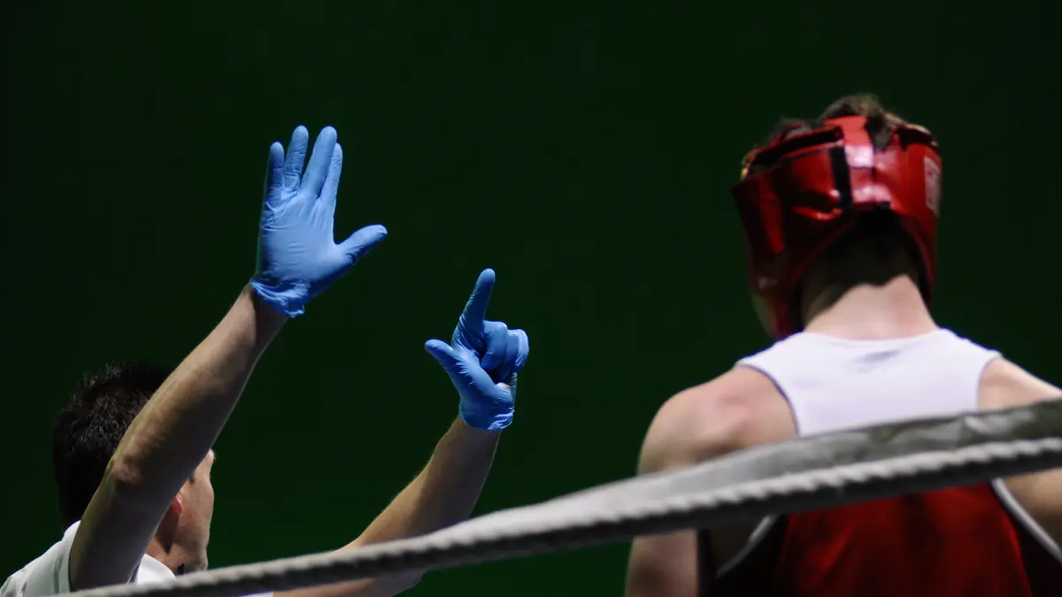L'arbitro alza il braccio del vincitore a bordo ring