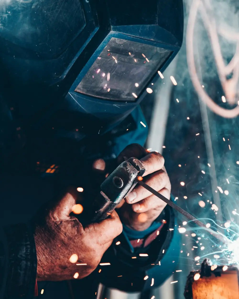 Saldatore al lavoro in carpenteria, tra le scintille