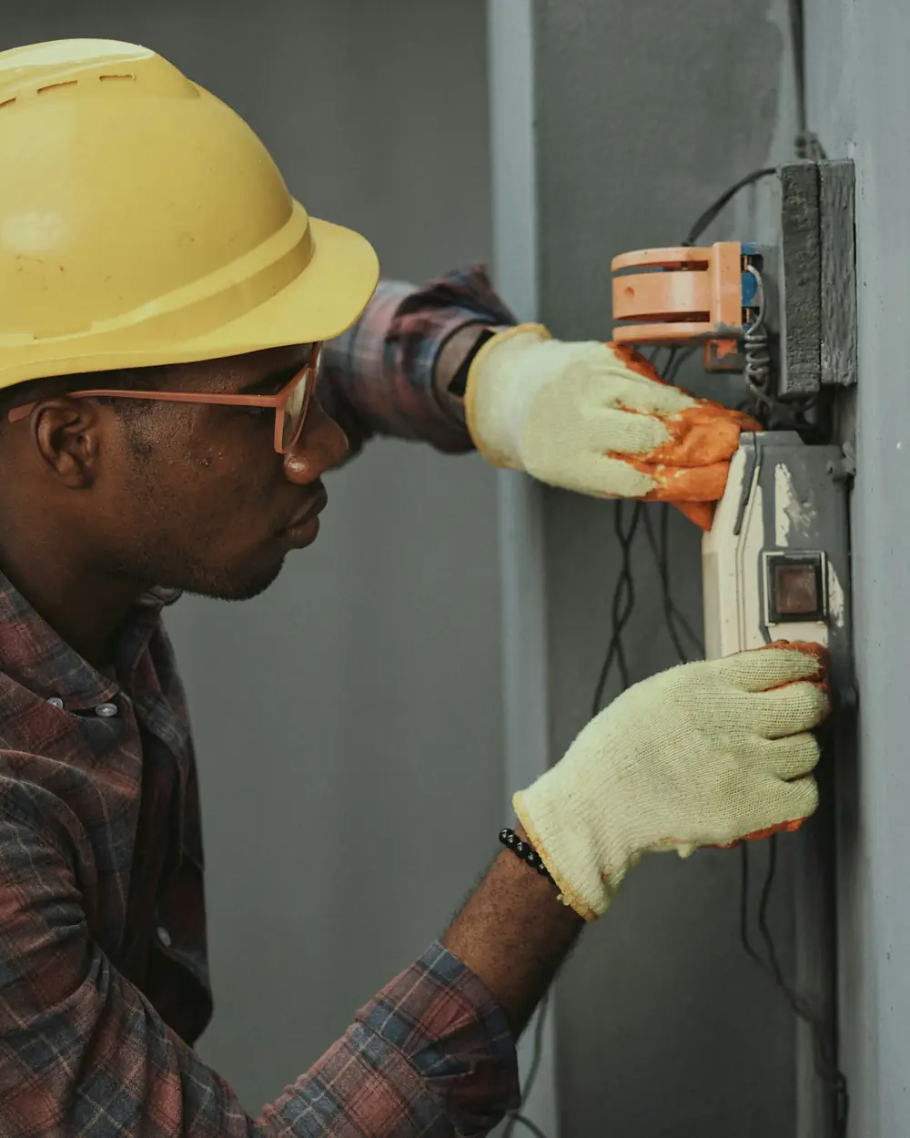 Elettricista con il casco che controlla un contatore