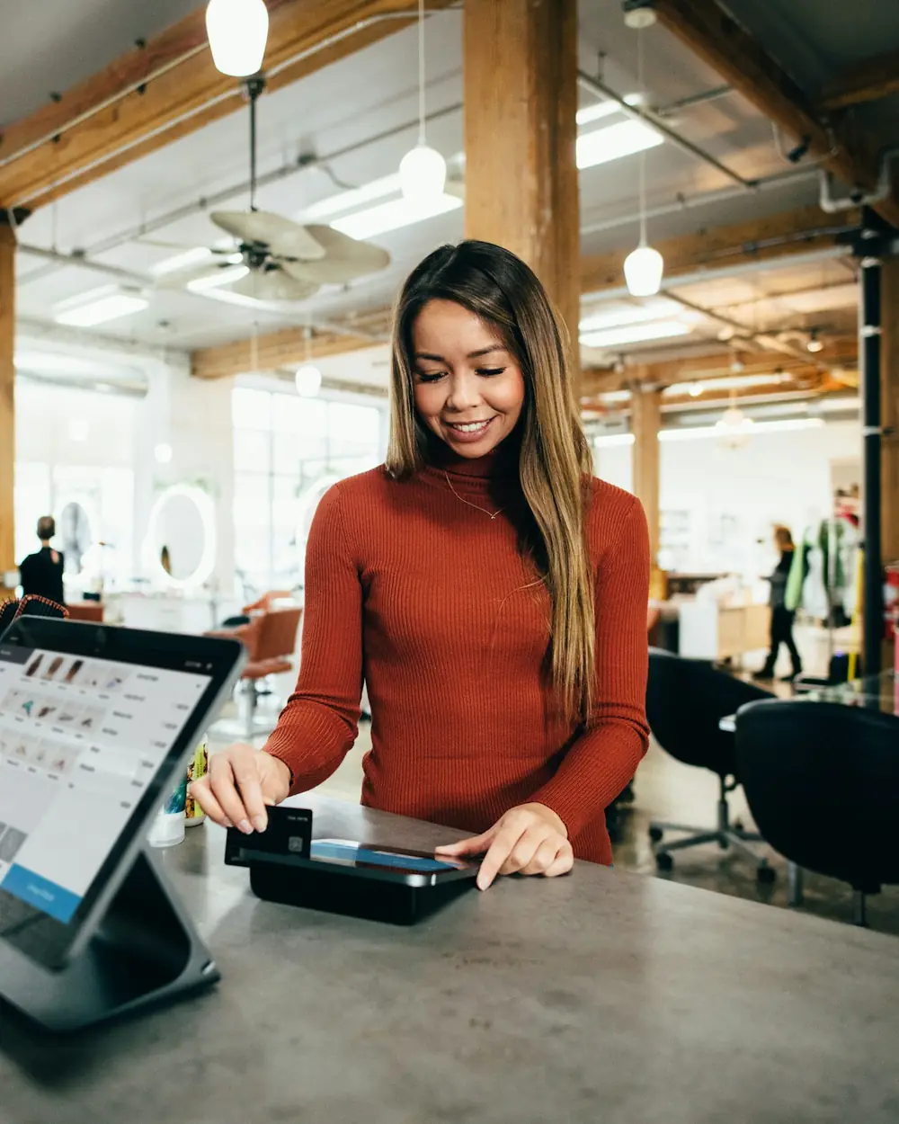 Negoziante che batte lo scontrino sul tablet alla cassa