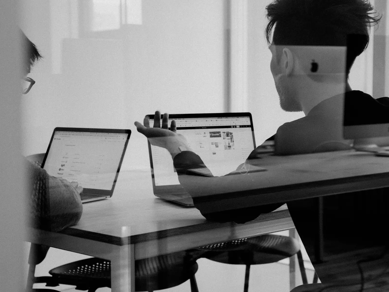 Due persone al lavoro con i portatili, in bianco e nero