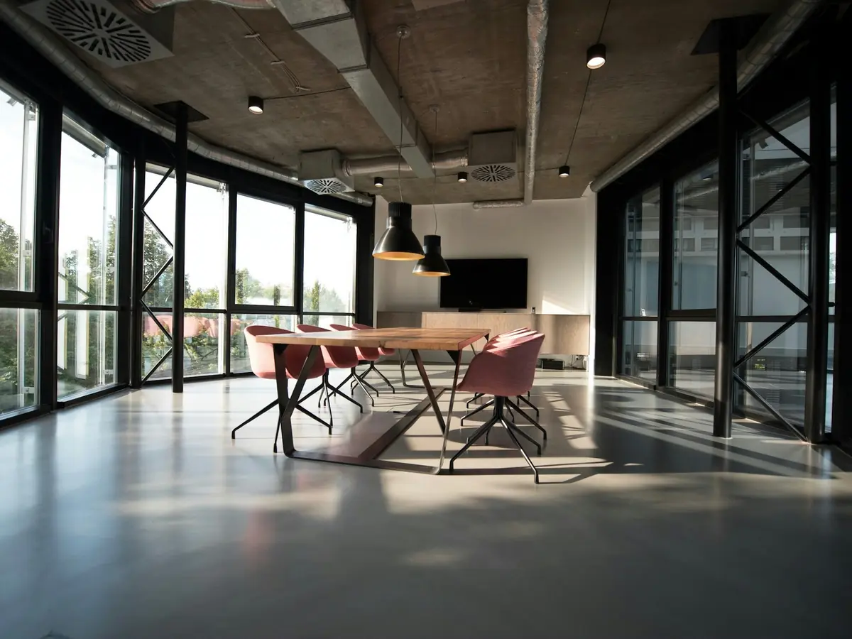Ufficio vuoto con grandi vetrate e un tavolo riunioni